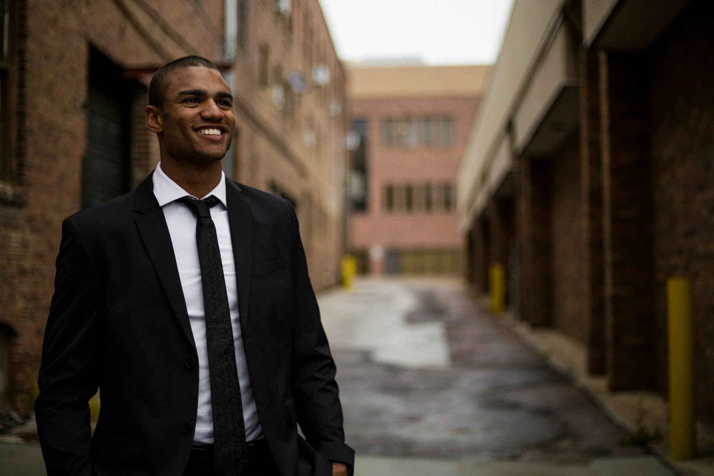 A smiling man dressed in a black suit.